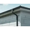 Ereszcsatornához csatlakozó antracit lefolyócső alumínium homlokzaton.