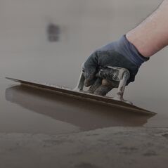 Betonpadló vagy vakolat felületének precíz elsimítása rozsdamentes simítóval.