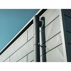 Homlokzati faláttörésre csatlakozó antracit PREFA lefolyócső.